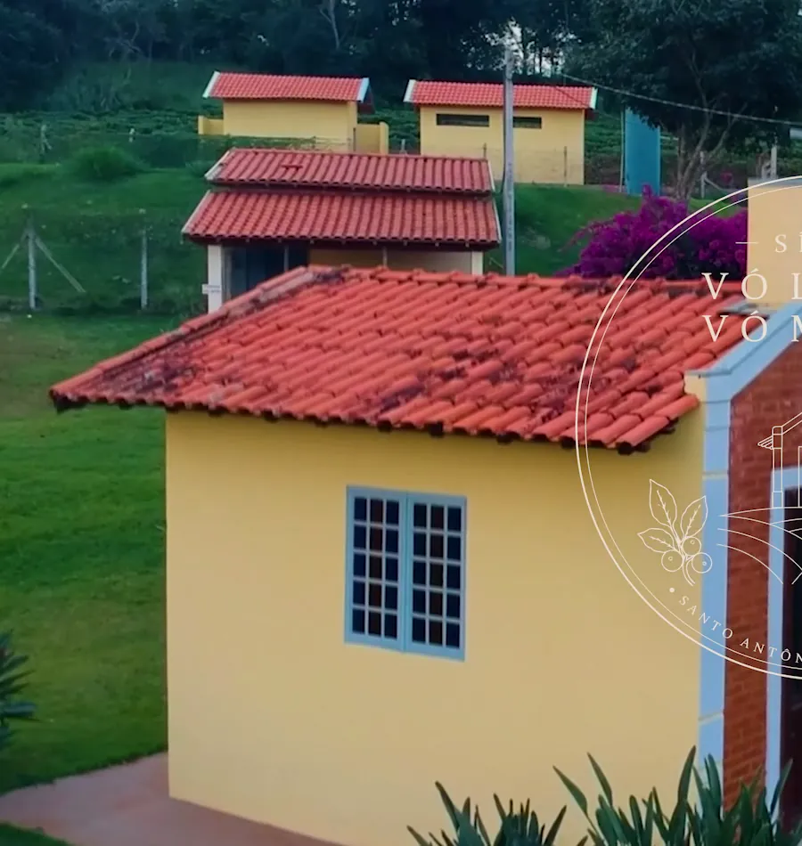 Detalhe da capela: parede amarela, janela azul e telhado de barro